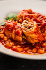Stuffed cabbage tomato sauce with beans meat, cabbage, fresh delicious gourmet food background on the table rustic food top view copy space