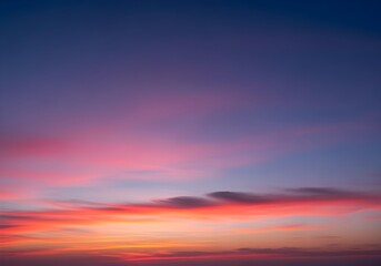 Obraz premium Vivid sunset sky with orange and pink clouds over soft gradient from warm golden horizon to deep blue, natural evening cloudscape view