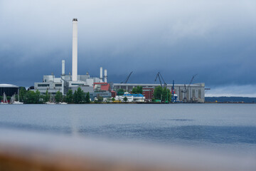Industrial harbor with yachts and cranes under gloomy rainy sky in flensburg in germany