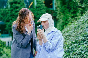 Friends reviewing photos together on smartphone outdoors