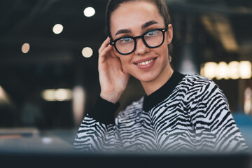 Portrait of smiling freelancer in glasses at modern office, illustrating personal confidence,...