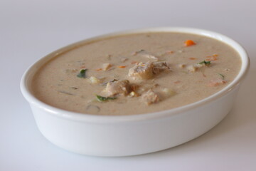 Kerala style mutton stew in a white bowl, made with tender mutton, carrots, coconut milk, curry leaves, and spices