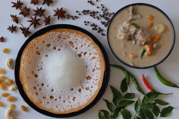 Kerala style appam with mutton stew in coconut milk gravy, styled with curry leaves, spices, and...