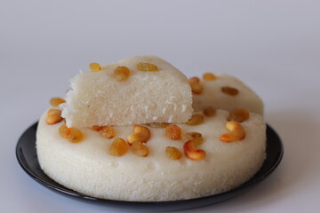Vattayappam, a steamed rice cake from Kerala, sliced and served on a black plate