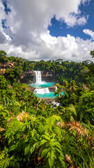Majestic tropical waterfall view in green jungle landscape. Serene nature with blue water flowing through lush forest full of green tree