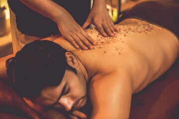 Man customer having exfoliation treatment in luxury spa salon with warmth candle light ambient....