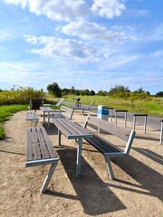 Modern outdoor seating area with wooden lounge chairs, tables and benches