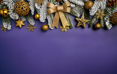 Christmas and New Year background with a festive scene with gold and red Christmas ornaments and fir tree branches on a purple background, symbolizing holiday spirit and elegance.