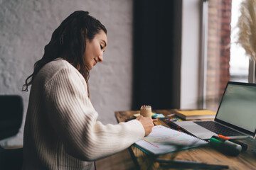 Freelancer sketching ideas near laptop, immersed in visual planning process that bridges creativity...
