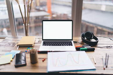 Open laptop with blank screen and surrounding office supplies symbolizes a digital blank slate, ready for ideas, online planning, creative input, and focused remote productivity.