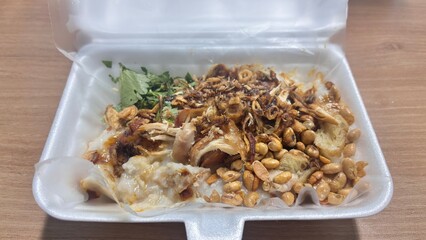 Delicious Chicken Porridge with Crispy Fried Onions and Soybeans in a Styrofoam Container.