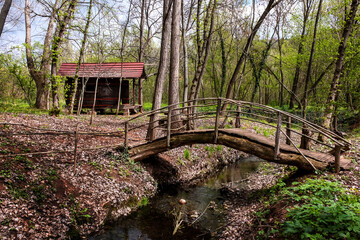 Old cabin in the woods. Old wooden cabin in the woods across a small stream and a wooden bridge