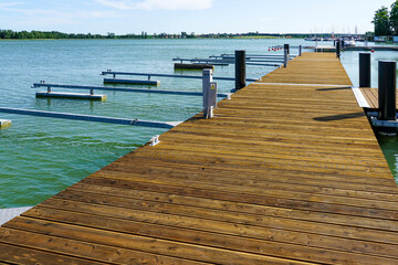Modern Wooden Marina Pier with Empty Moorings on a Sunny Day at a Peaceful Lakeside Harbor