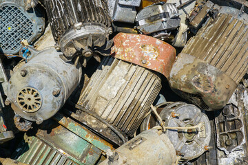 Heap of old electric motors and industrial machinery parts awaiting recycling process