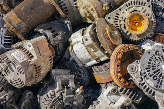 Pile of rusty alternators and car generator parts prepared for recycling and scrap metal