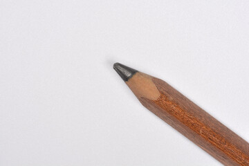 A close-up, diagonal shot of the tip of a large pencil against a clean white background