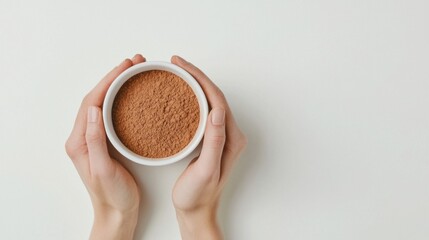 Hands hold nutmeg powder cup top view