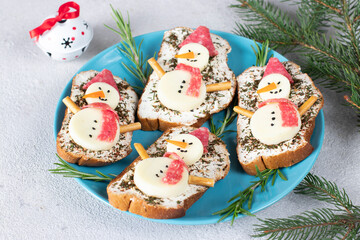 Sandwiches with mozzarella cheese and sausage, decorated with snowmen