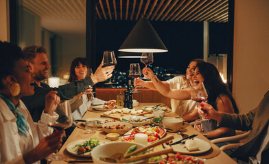 A group of friends enjoying food and drinks together at night