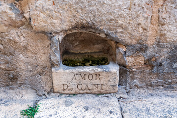 An ancient stone drinking fountain for dogs with the Latin inscription 'Amor D. Cani' or Love of...