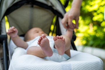 Newborn baby feet in the baby carriage, infant foot first week of life. 