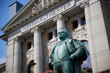 Statue of Bj&oslash;rnstjerne Bj&oslash;rnson in Front of the Historic Nationaltheatret Building in Oslo, Norway with Neoclassical Architecture on a Clear Day