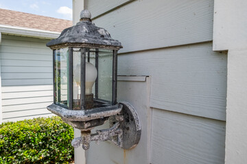 Old Corroded Light Fixture Needing Replaced Attached to the Siding of a House