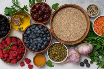Anti-Inflammatory Food Set with Berries in Wooden Bowls, Quinoa, Lentils, Turmeric, Olive Oil, and...