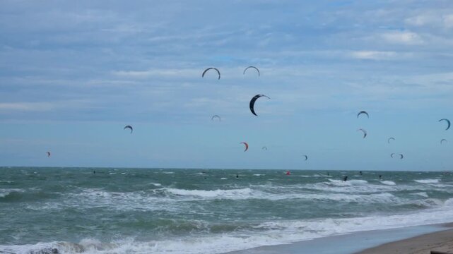 Kitesurfers at Pre&aacute; Beach, Cear&aacute;, Brazil, with colorful kites in the sky, waves and a vibrant seaside sports atmosphere.