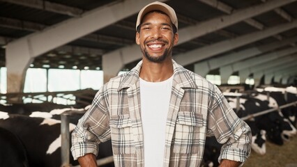 Camera moving toward happy handsome man farmer in cap standing indoor in barn and smiling to...