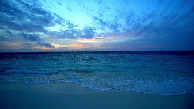 Beautiful sunset over the sea with waves crashing on the beach at twilight