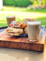 Toasted ham and cheese sandwiches with latte outdoors