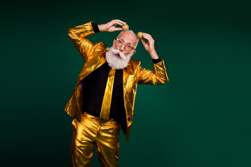 Charismatic gentleman in a glowing golden suit poses playfully against a vibrant green background,...