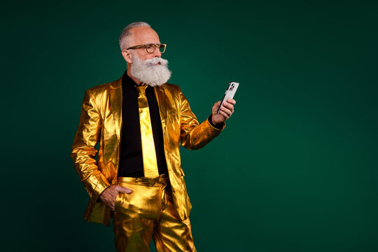 Charismatic elderly man in gold suit celebrates holiday with vintage style against green background - Powered by Adobe