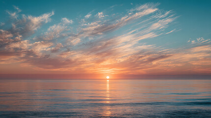 Obraz premium Golden sun setting over calm ocean waters with wispy clouds sunset