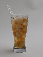 Iced lychee tea in a glass with glass straw