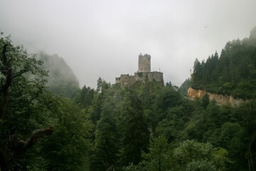 Zil Castle atop a mountain, surrounded by lush green forest and mist