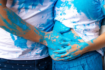 Happy couple at a baby gender reveal party. Gender party. Dad, mom T-shirt. In the photo, the hands...