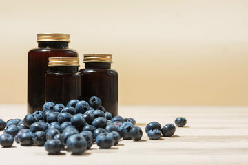 Blueberries and Bottles of Blueberry Syrup on Wooden Surface