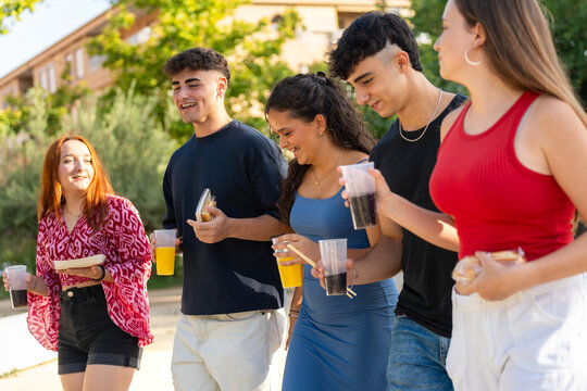 Young people walking and eating street food together