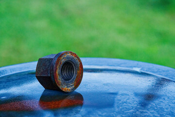 Large rusty metal nut resting on a metallic surface