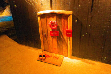 Miniature wooden door with wreath, red mailbox, mat and shoes for danish julenisse