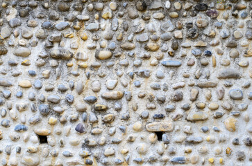 Wall made of river pebbles with unique texture and natural background