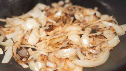 Perfectly golden fried chopped onions sizzling in a pan. Ideal for cooking tutorials, recipe backgrounds, and food advertising visuals.