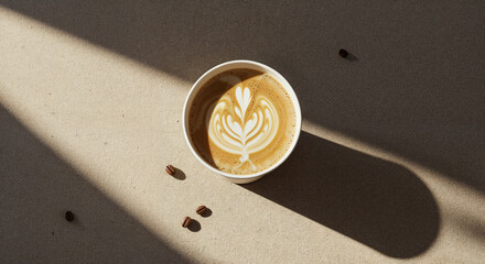 Top view of a coffee to go cup on a textured beige linen background, dappled sunlight, early morning.