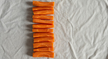 top view of fresh raw ripe carrot slices arranged in vertical row isolated on white