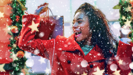 Cheerful young adult woman enjoying holiday shopping amidst festive decorations and snowflakes