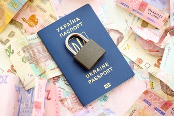 Big amount of different Ukrainian hryvnia money bills and passport with padlock