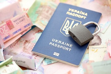 Big amount of different Ukrainian hryvnia money bills and passport with padlock