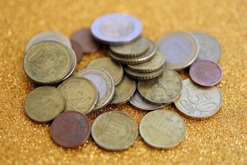 Big amount of euro coins on golden glitter background